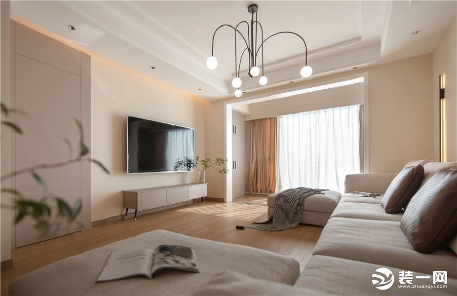 客厅搭配大U字型的沙发，白色的沙发更显干净整洁，而且跟整个空间的色系都非常搭。吊灯采用的是线型的