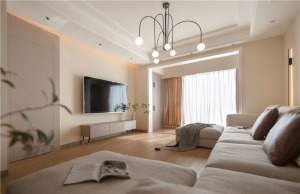 客厅搭配大U字型的沙发，白色的沙发更显干净整洁，而且跟整个空间的色系都非常搭。吊灯采用的是线型的