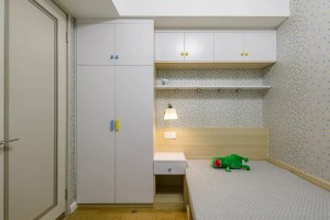 儿童房墙面贴着碎花墙纸，床铺、床头柜与衣柜整体链接一体的定制设计