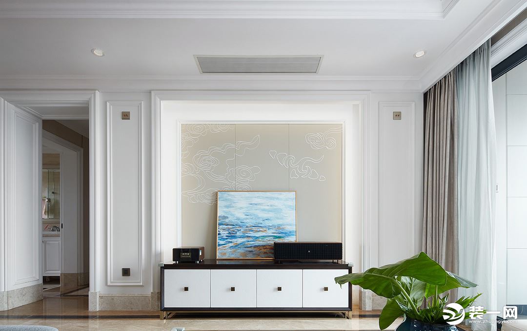 客厅的电视墙选用了淡米金色，墙上的祥云为休憩的时光带来安逸与惬意的意味。没有过多复杂的装饰，而是完美