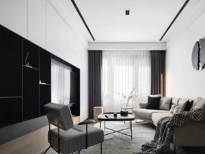 客厅以白色为主调，穿插黑色电视柜和浅灰色沙发，统一中又不乏单调，顶部无主灯设计，简约大气