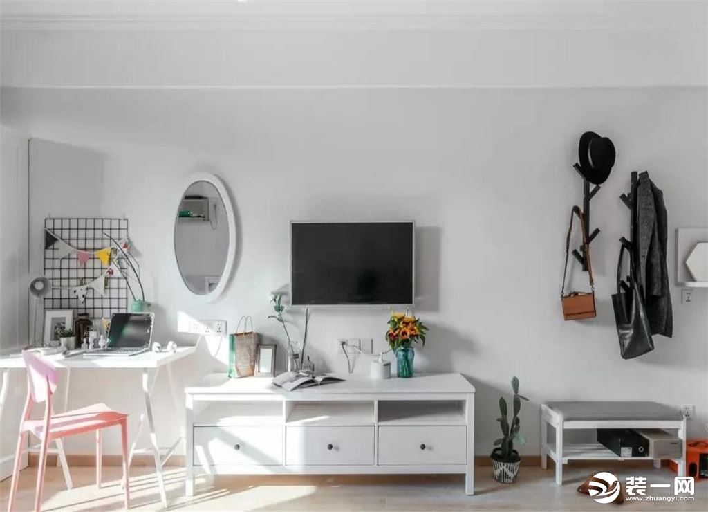 整个房子是个长条形的格局，换鞋凳、电视柜和书桌、衣柜呈一字形摆放，整体白色的墙面搭配温馨的木地板，显