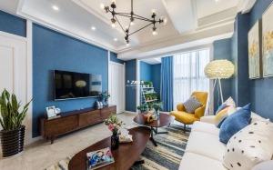 客厅选用的布艺沙发与实木的茶几、角几、电视柜，色彩上深浅、明暗搭配，十分具有视觉冲击力。