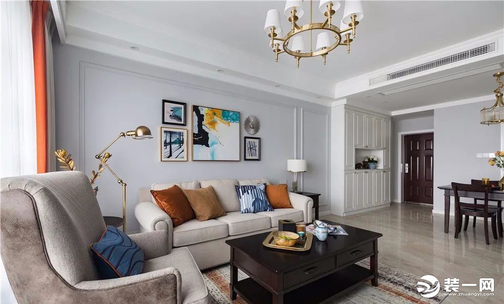 布艺沙发  浅色布艺沙发与素雅舒适的单人沙发彰显经典美式风格，抽象的装饰画提升了家居的空间感，起到点