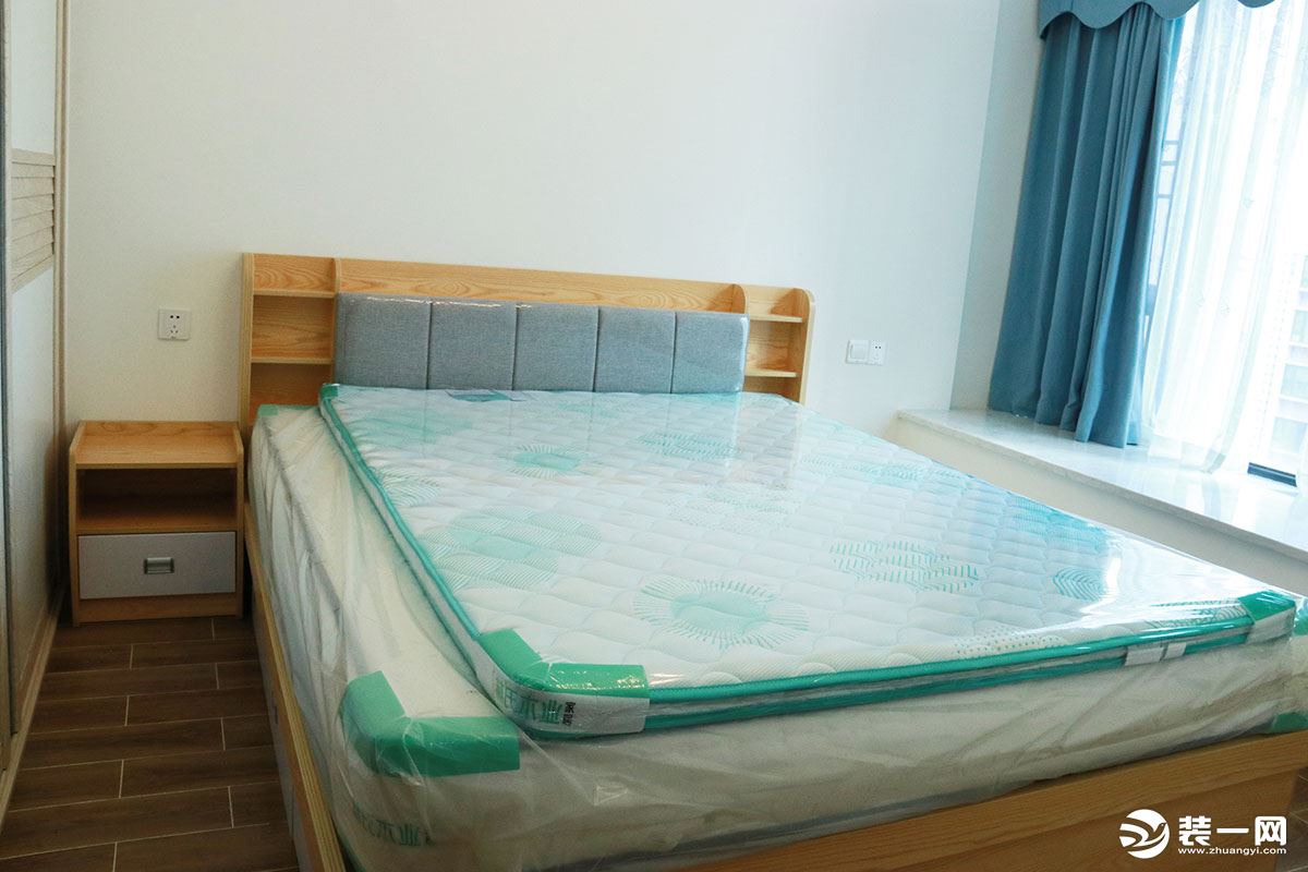 主卧的床与床头柜等都是采用了同一个色调的木质家具，协调而统一