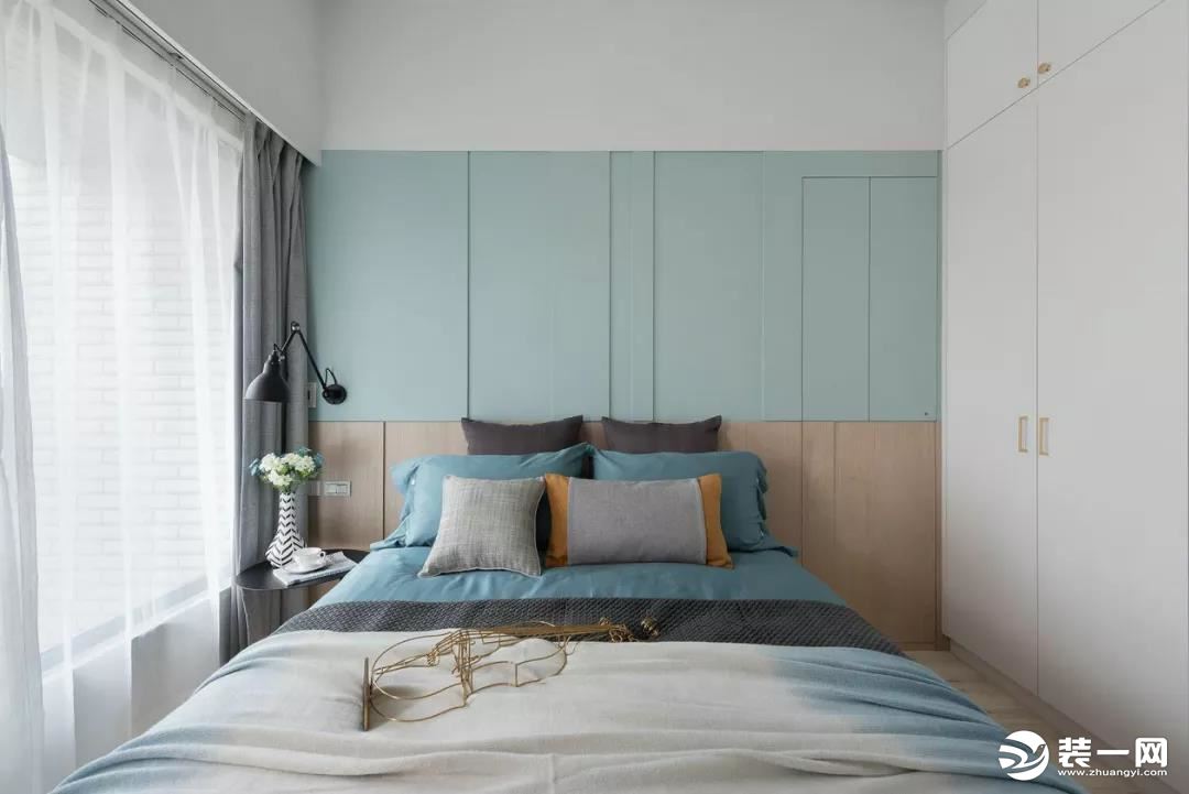  ▲卧室床头墙是以护墙板的设计，木质墙脚+淡蓝色墙身，搭配上素雅精致的床单布置，让空间感显得静雅而舒