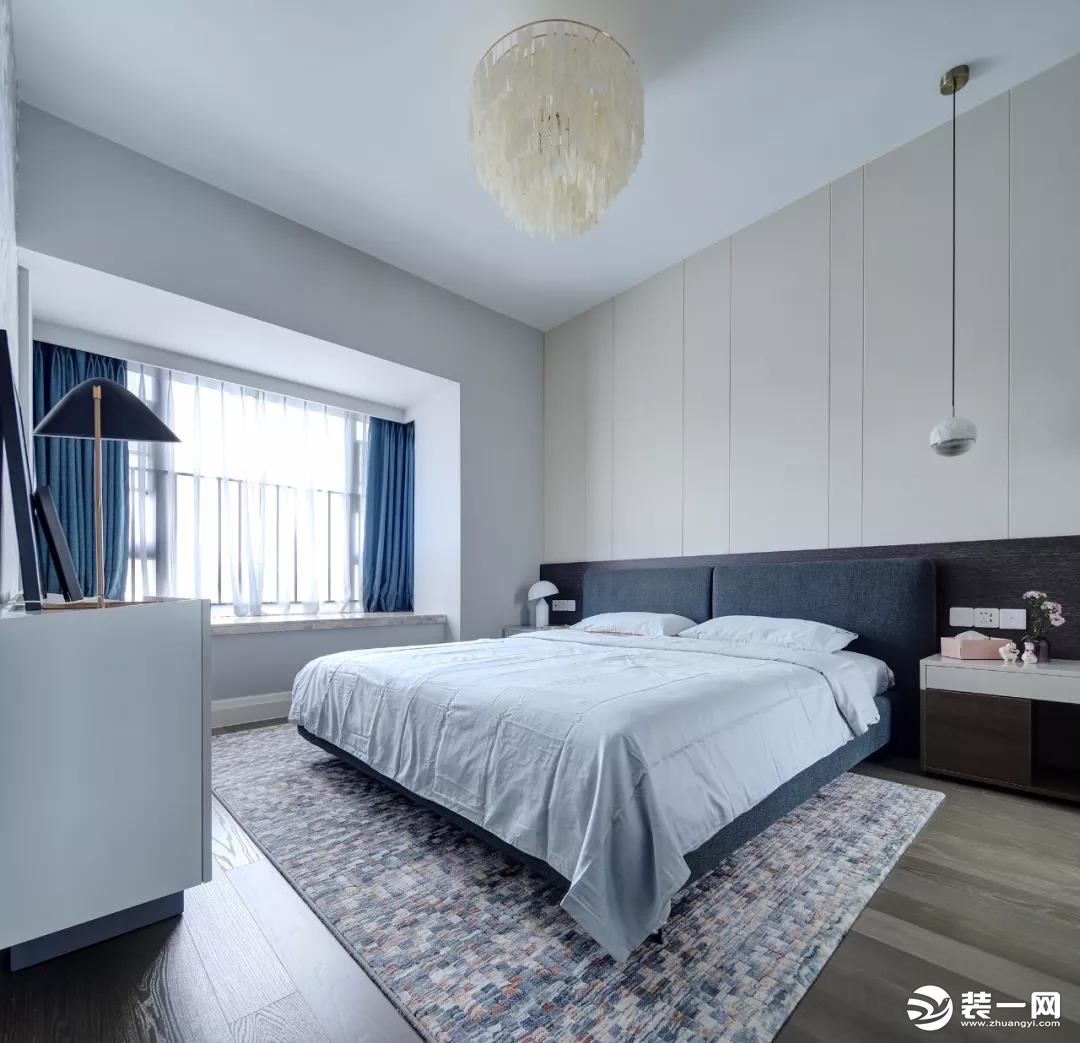 卧室整体现代简洁的空间，灰蓝色的的空间感，地面是马赛克地毯，让空间充满了安静舒心的氛围感。