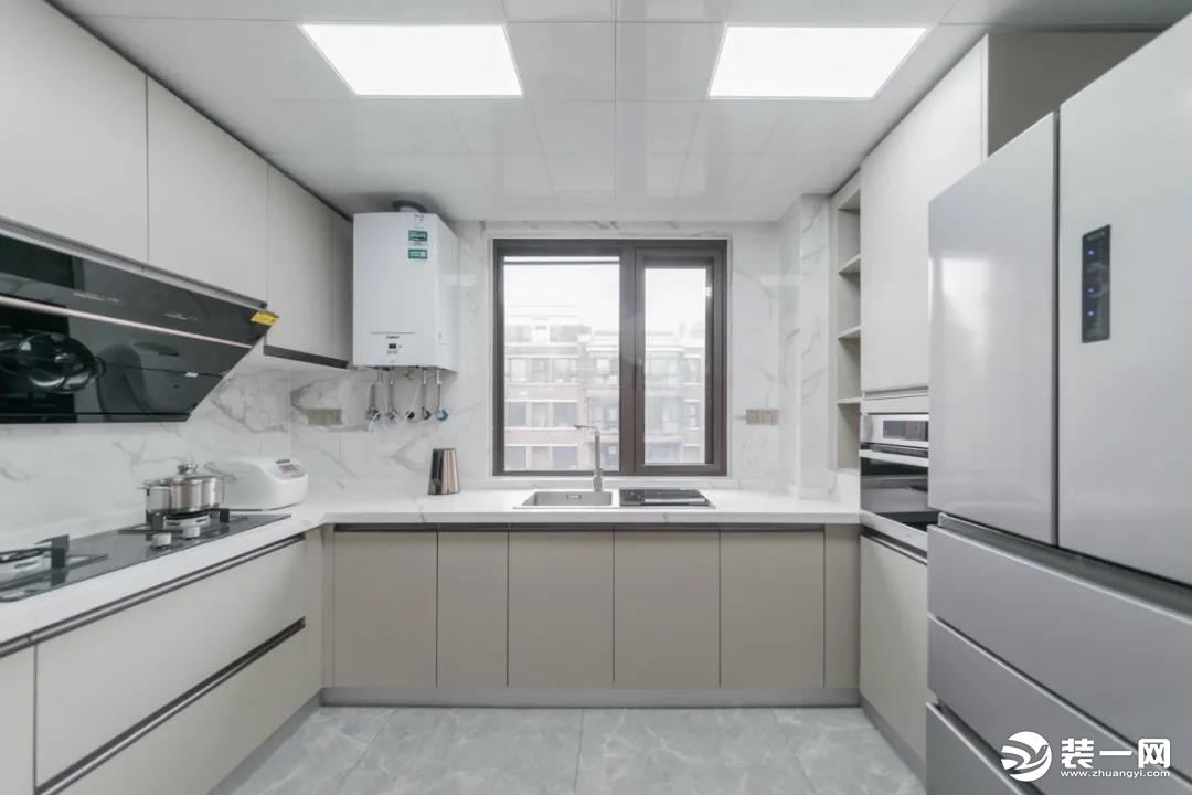 U字形的厨房布局，操作台是L形设计，另一侧布置电器柜+冰箱摆放位置，整体空间宽松实用的布置，让做饭体