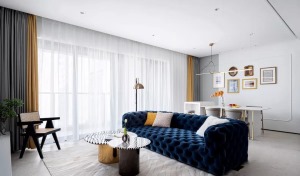 客厅围绕深蓝色沙发奠定复古优雅的基调，地毯、茶几上简约流畅的线条，让空间富有灵动的魅力。