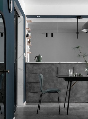 餐厅和卧室间的非承重墙被改造为吧台 一面做了餐边柜 使用和地面一致的水泥灰色做柜面 让柜体隐形的同时