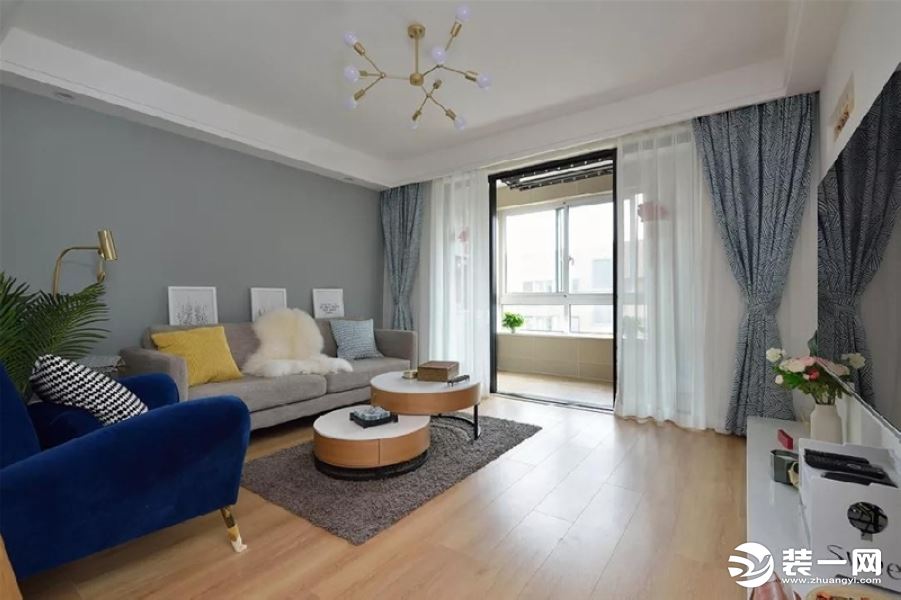 客厅色调以灰白色为主，搭配深蓝色单椅，以及姐姐亲手编织的沙发垫，感觉十分自然舒适。