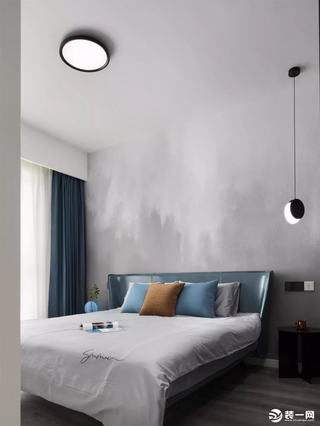 主卧室的床头背景墙铺贴了朦胧感十足的壁纸，结合这个款式独特的床、吊灯和主灯，给人一种时尚大方的感觉。