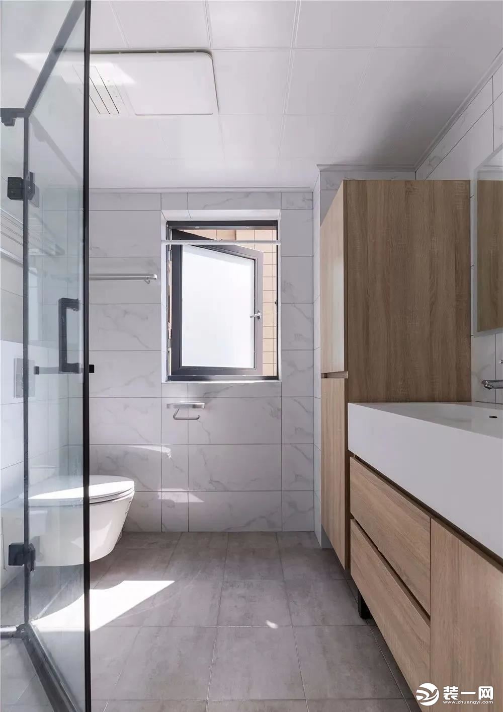 卫生间简洁明亮，在满足正常使用面积基础上加大储物空间，增强功能性，木色浴室柜为冷色空间增加自然温暖的