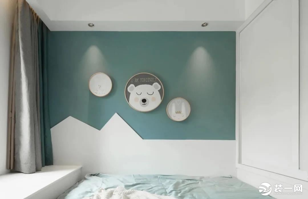 床的里侧墙面在暗蓝色的墙面基础，墙脚区域装上小山形状的护墙板，上方墙面挂着圆形的动漫图案装饰画