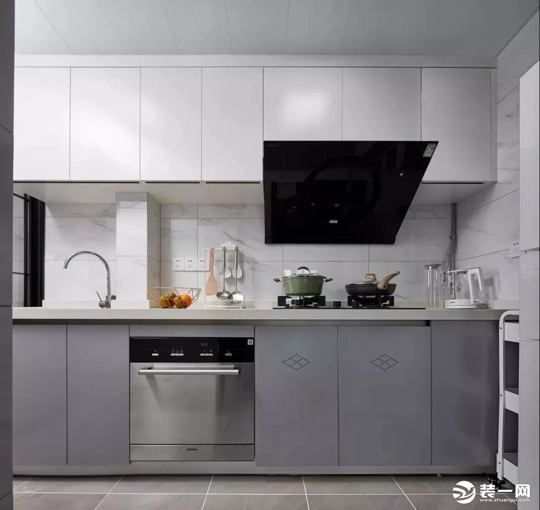 厨房，色系沿用整体的灰白格调，墙面选用爵士白瓷砖搭配简洁的平板柜门橱柜，整个空间给人清爽且有品位质感