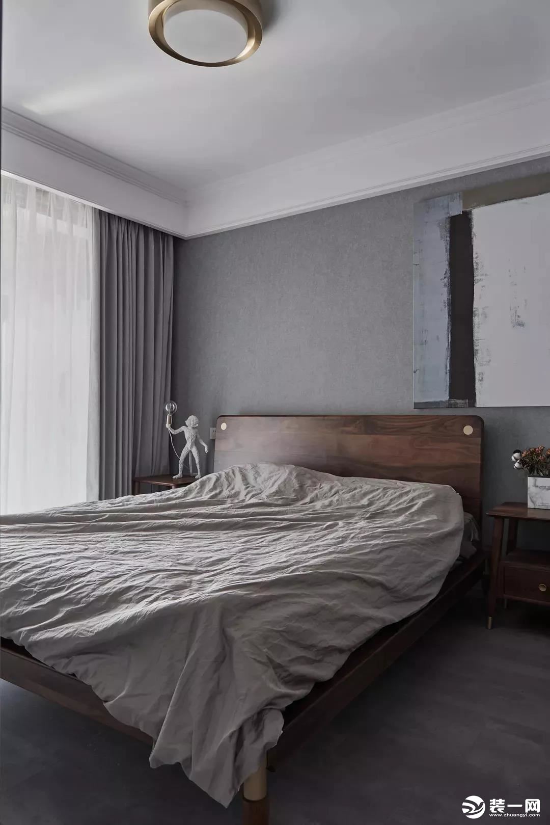 次卧的天花板刷成了白色，墙面和走廊一样，也是铺贴了灰色的壁纸，再加上实木的床、床头柜
