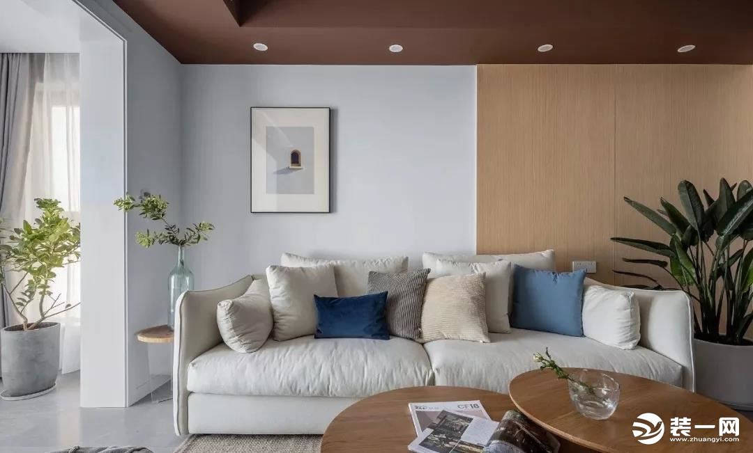 沙发背景以白色与木饰面板拼接，搭配米白色布艺沙发和自然木纹茶几，配比合理，自然纯净