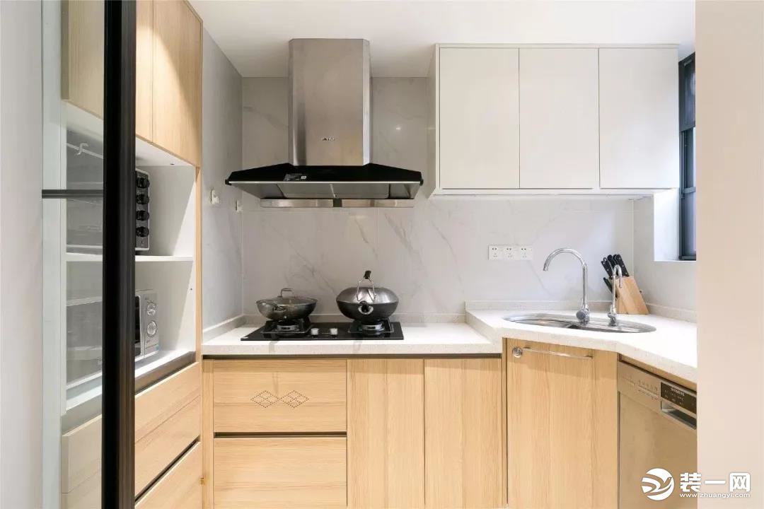 厨房以雅白的墙面，搭配原木橱柜与白色操作台，让烹饪氛围简洁优雅自然。