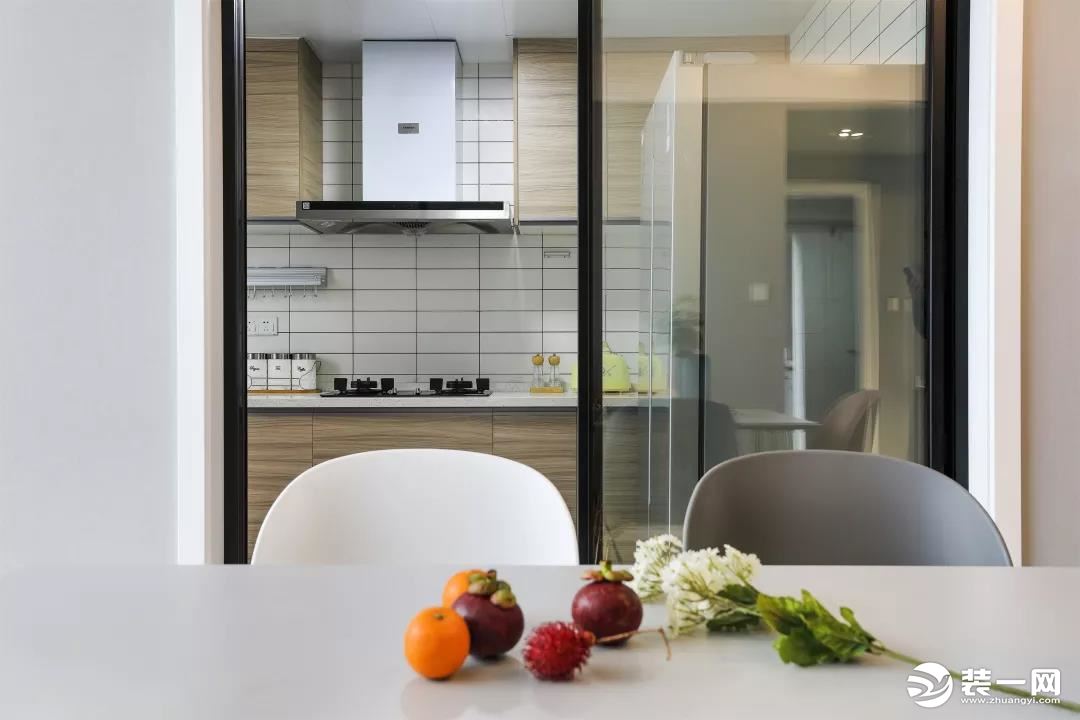 厨房位于黑框玻璃门的后方，这样的设计可以避免油烟问题，又能保证光线的流通。
