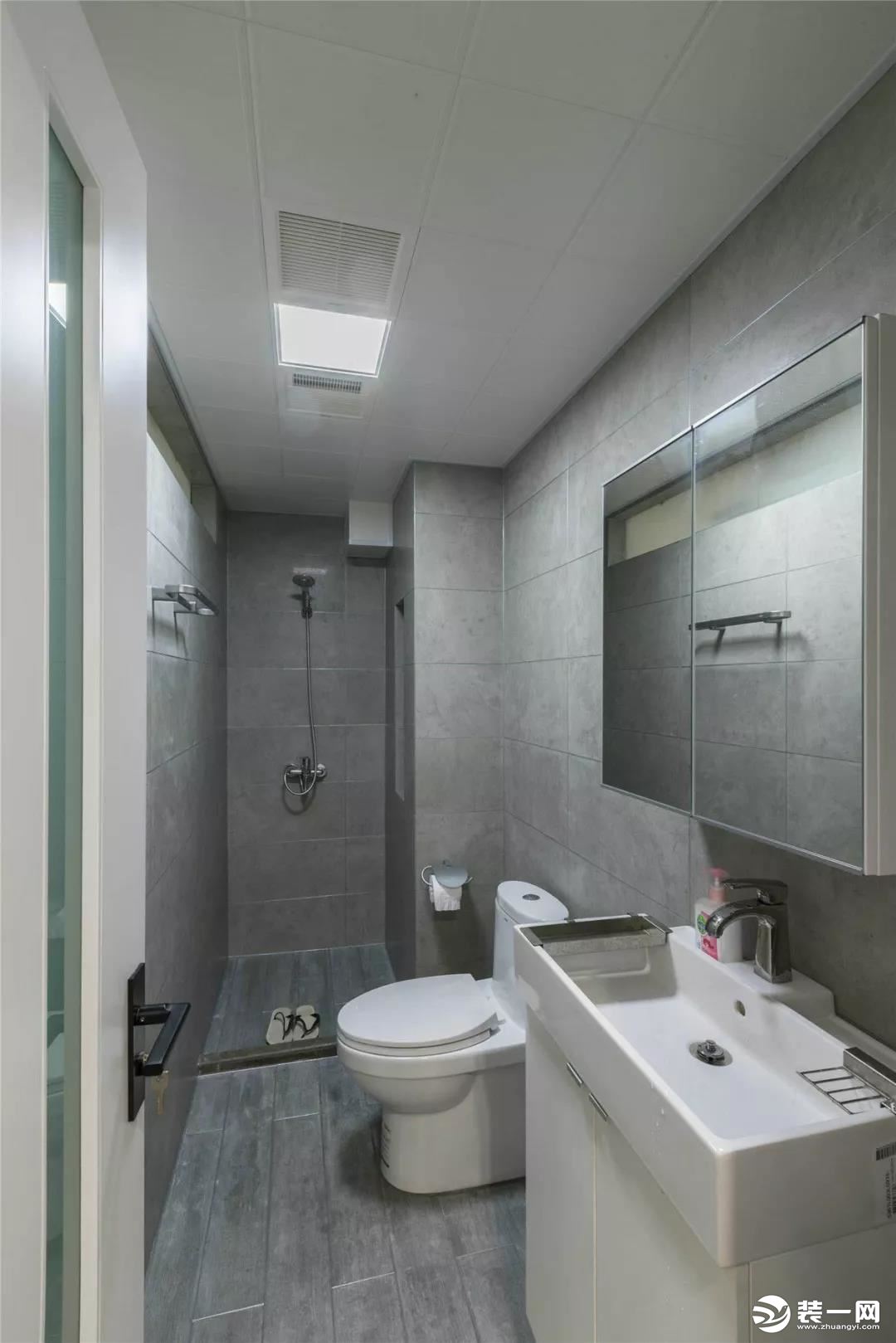 卫生间内通铺灰色调的哑光砖，搭配白色的卫具看起来很简洁、轻松。