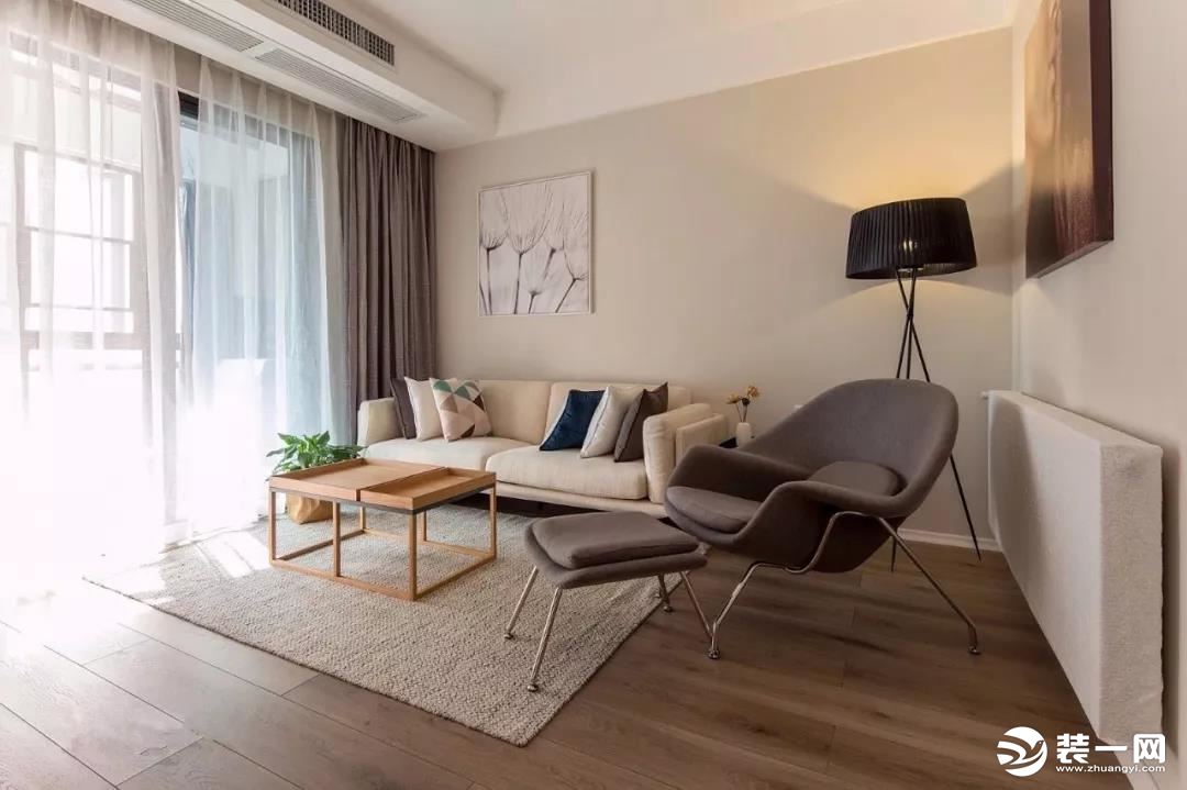 客厅处的设计让人感觉温馨而又有格调感，咖色的沙发背景墙和米色的布艺沙发结合