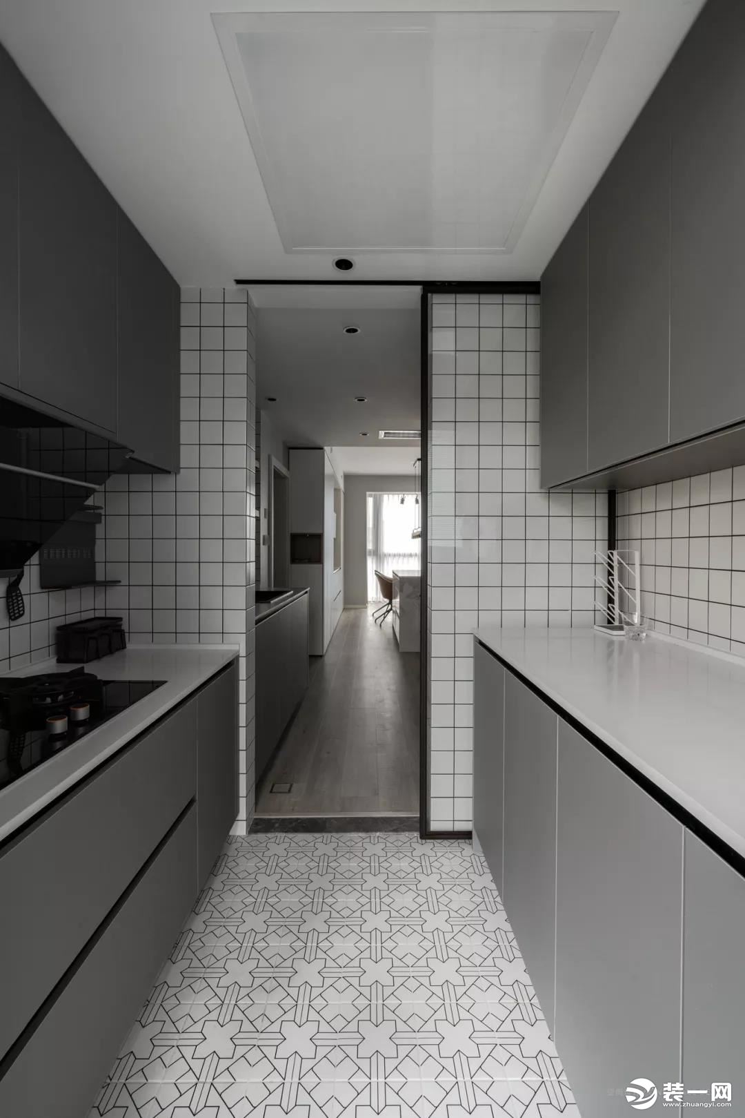 中厨区域，二字型的操作台格局，白色花砖、灰色橱柜、墙面是白色小格砖，整体简约文艺，也让做饭显得轻松方