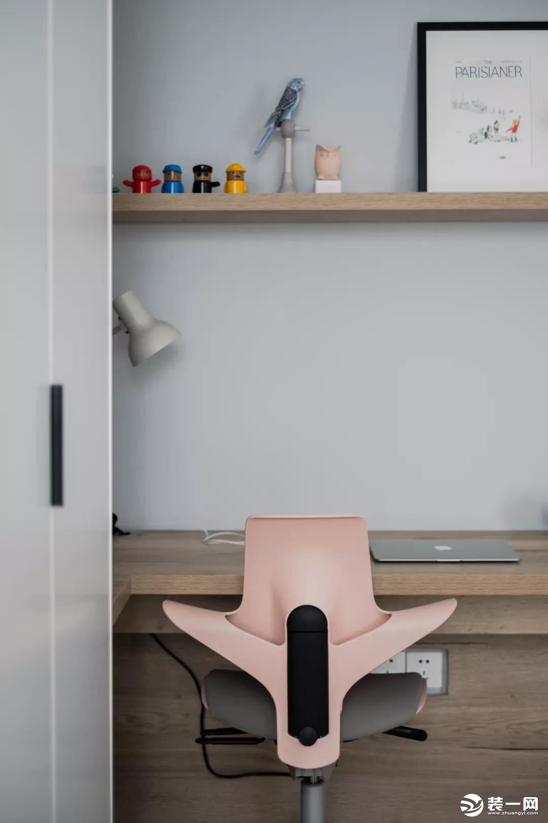 桌上方的隔板架，上边摆着小手办与装饰画，搭配一张粉色电脑椅，简单童趣的布置