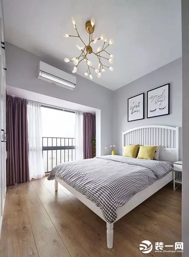 主卧室的床头背景墙是简单的刷上了乳胶漆和点缀两幅挂画，格子状的床品和紫色的窗帘给这个卧室带来了更为优