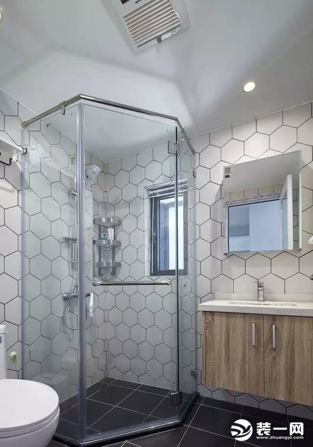 卫生间的钻石型淋浴房被放在了转角的位置，白色的六边形墙砖搭配黑色的地砖，加入木质的浴室柜，整个空间显