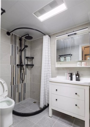卫生间整体通铺石色瓷砖，白色成品浴室柜配黑色卫浴五金， 安装弧形挡水条配浴帘，简洁省预算