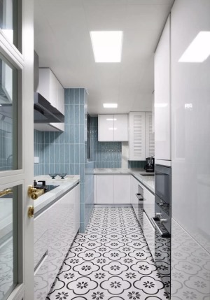 厨房的设计以小清新为主，地面铺贴黑白色的花砖，墙砖选择了蓝色系，L型的橱柜搭配另一侧的一字型橱柜