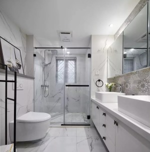卫生间整体以白色的大理石墙地砖为基调，浴室柜和镜柜之间做了花砖来进行装饰，双洗手盆的设计