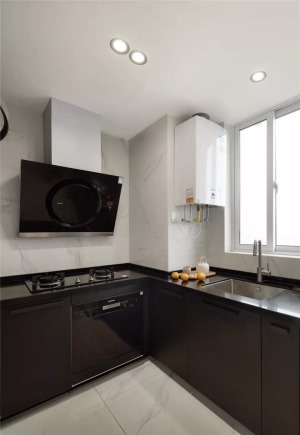厨房内部是L形的橱柜布局，选择了黑色的橱柜搭配白色的大理石墙砖