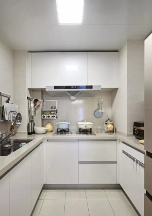 厨房内部做了U字型的橱柜布局，白色的橱柜搭配浅灰色的墙地砖和台面，显得年轻大方。
