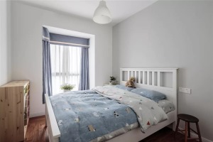 次卧的墙面被刷成了灰色，白色的木床搭配木色的柜子，床品和窗帘选择了蓝色的款式，让次卧看起来更有小清新