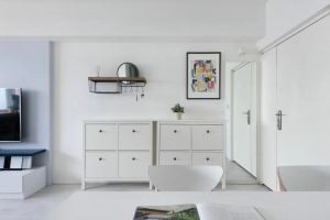 为了不让纯白色的空间过于单调，设计师巧妙利用了墙面空间，增加家居装饰，为纯白空间增添色彩。