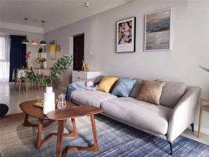 沙发墙挂上两幅现代简洁的装饰画，搭配一张暖灰色的布艺沙发，使得空间充满了舒适优雅的氛围。