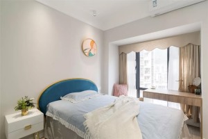 次卧整体空间也比较简约，蓝色的床头靠背，结合床头墙的圆形挂画，使得空间简洁又优雅温馨。