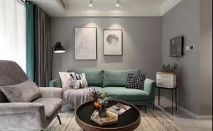 客厅是典型的北欧风格，灰色的乳胶漆墙面带来一种高级感，墨绿色的双人沙发搭配一张灰色的单人椅