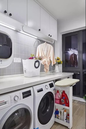 在入户玄关的侧面是有着一个独立的洗衣房，洗衣机、烘干机和柜子的结合