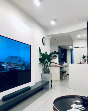 电视背景墙设计简单，把电视机嵌入大白墙里，采用悬空的台面代替电视柜，看起来更轻盈简约