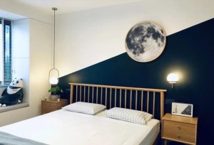 主卧，床头背景墙白色拼接深蓝色，安静又有创意，床头两侧的灯具都是不对称的设计，很有创意。