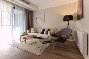 客厅处的设计让人感觉温馨而又有格调感，咖色的沙发背景墙和米色的布艺沙发结合
