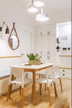 白色卡座餐椅靠墙安装，底部空间设计成了收纳柜。白色搭配木色餐桌餐椅，款式简洁大方。
