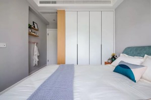 床侧白衣柜入墙，配合走道墙面的衣钩和搁板收纳，简单中也不乏实用性。