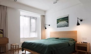 墨绿色床品瞬间提升空间气质，搭配米色窗帘，让留白空间能够和木质家具与地面自然衔接