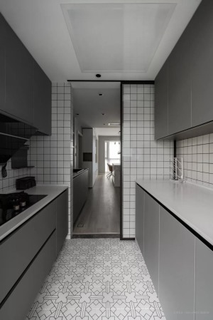 中厨区域，二字型的操作台格局，白色花砖、灰色橱柜、墙面是白色小格砖，整体简约文艺，也让做饭显得轻松方