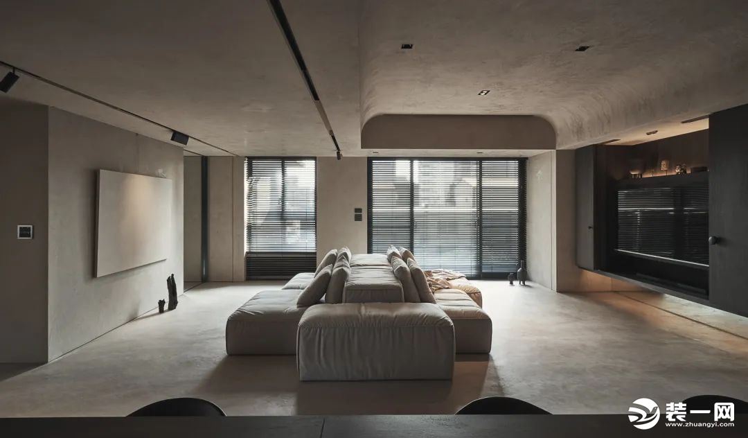 客厅以水泥灰的空间硬装，沙发背靠背的创意布局，使得开间巨大的客厅有着“两侧”的客厅功能，使得客厅空间