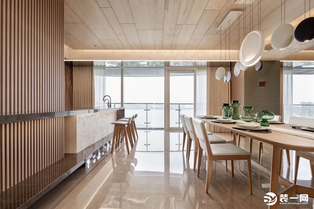 餐厨区也以木质感的硬装与家具搭配，开放式的餐厨设计结合大面积的落地窗，带来一种明亮宽敞的空间氛围感。