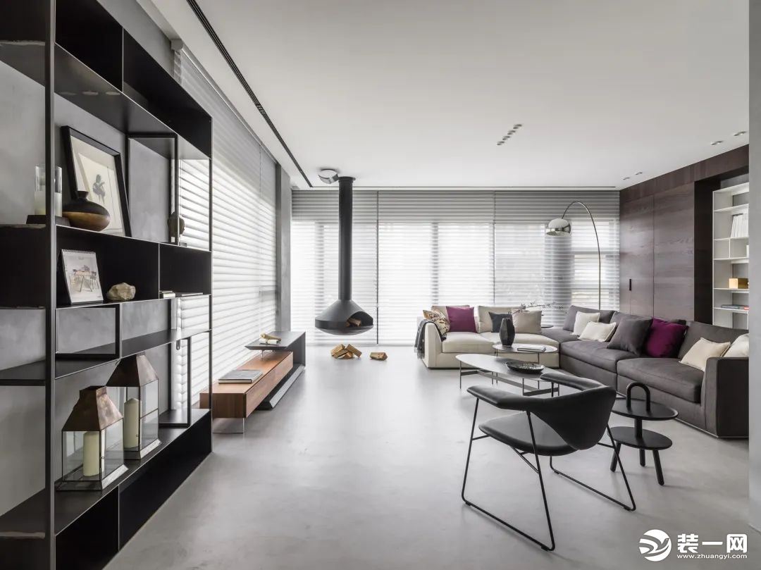 客厅整体现代极简的空间，天花以无主灯的设计，搭配上灰色与米白色的布艺沙发、岩板茶几，双面采光的窗户以